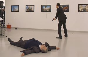 This picture taken on December 19, 2016 shows Andrey Karlov (L), the Russian ambassador to Ankara, lying on the floor after being shot by a gunman (R) during an attack during a public event in Ankara. A gunman crying "Aleppo" and "revenge" shot Karlov while he was visiting an art exhibition in Ankara on December 19, witnesses and media reports said. The Turkish state-run Anadolu news agency said the gunman had been "neutralised" in a police operation, without giving further details. / AFP PHOTO / STRINGER