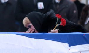 Marina Davydova Karlova, widow of late Russian Ambassador to Turkey Andrei Karlov, reacts in front of his coffin, during a ceremonial farewell with full state honours on the tarmac of Ankara's Esenboğa Airport on December 20, 2016. / AFP PHOTO / ADEM ALTAN