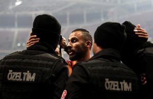 Galatasaray player Yasin Oztekin (C) hugs Turkish policemen after scoring a goal on December 11, 2016, a day after twin attacks near the home stadium of Besiktas football club. Turkey declared a day of national mourning after twin bombings targeting police struck the heart of Istanbul near the home stadium of football giants Besiktas, killing 38 people. / AFP PHOTO / STR