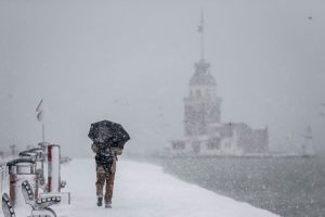 A man walks in a snow covered sidewalk near the Bosphorus during the heavy snowfall in Istanbul, Turkey on January 07, 2017. Arif Hudaverdi Yaman / Anadolu Agency