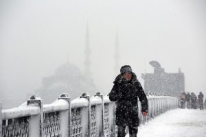 A man walks on snow covered Galata Bridge over the Golden Horn during the heavy snowfall in Istanbul, Turkey on January 07, 2017. Erhan Sevenler / Anadolu Agency