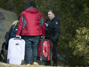 A man who claimed to be from Turkey is questioned by the RCMP after crossing the US/Canada border February 27, 2017, in Champlain, New York. There continues to be an increasing number of people crossing the US border into Canada illegally. / AFP PHOTO / Don EMMERT