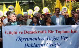 People hold a banner reading "Give the teachers the rights for a strong and democratic society" asd they take part in a demonstration of Turkish teachers outside the Turkish Education Ministry in Ankara, on October 5, 2016 to protest against the government's education policies and to call for secularism in education. / AFP PHOTO / ADEM ALTAN