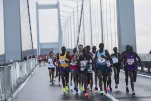 Stephen Kiprotich of Uganda (R) runs with participants on the July 15 Martyrs' Bridge, known as the Bosphorus Bridge, during the 38th annual Istanbul Marathon on November 13, 2016. / AFP PHOTO / YASIN AKGUL